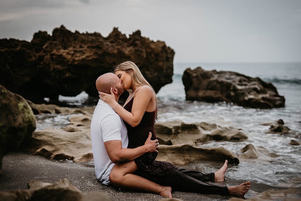 Woman kissing and saddling man on the beach
