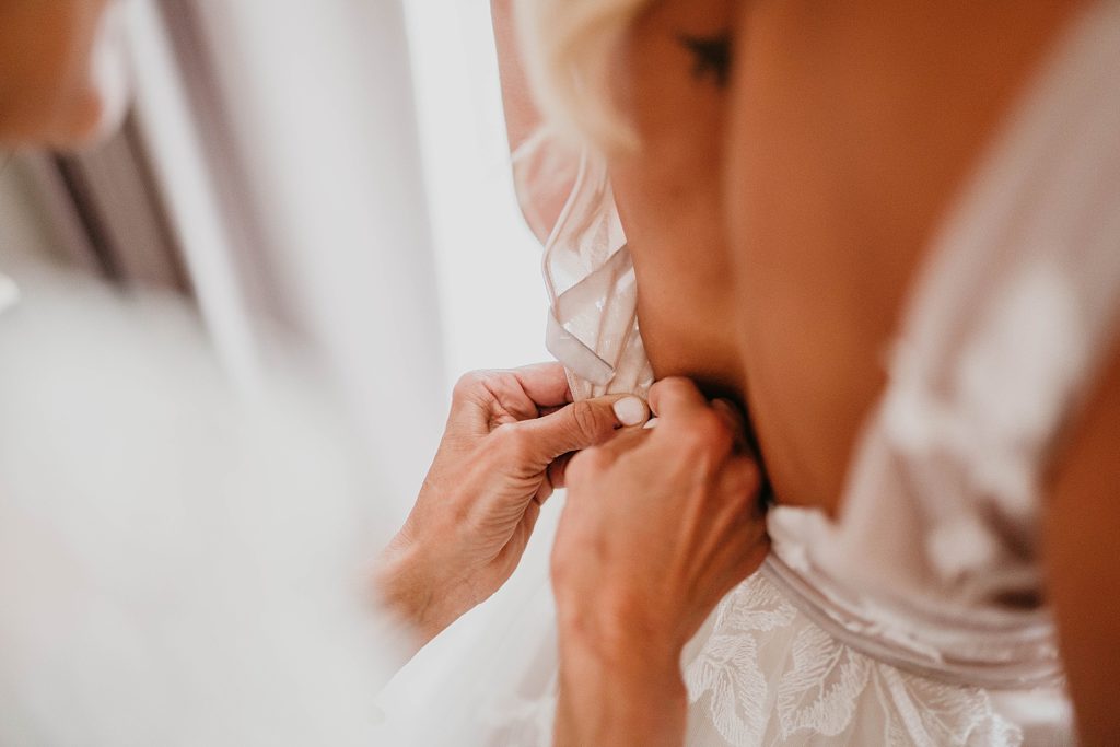 Closeup of Wedding Dress getting button up