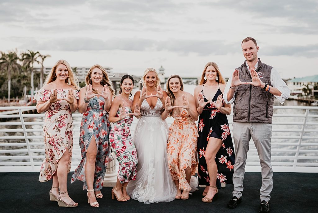 Bride doing hand signal with sorority friends
