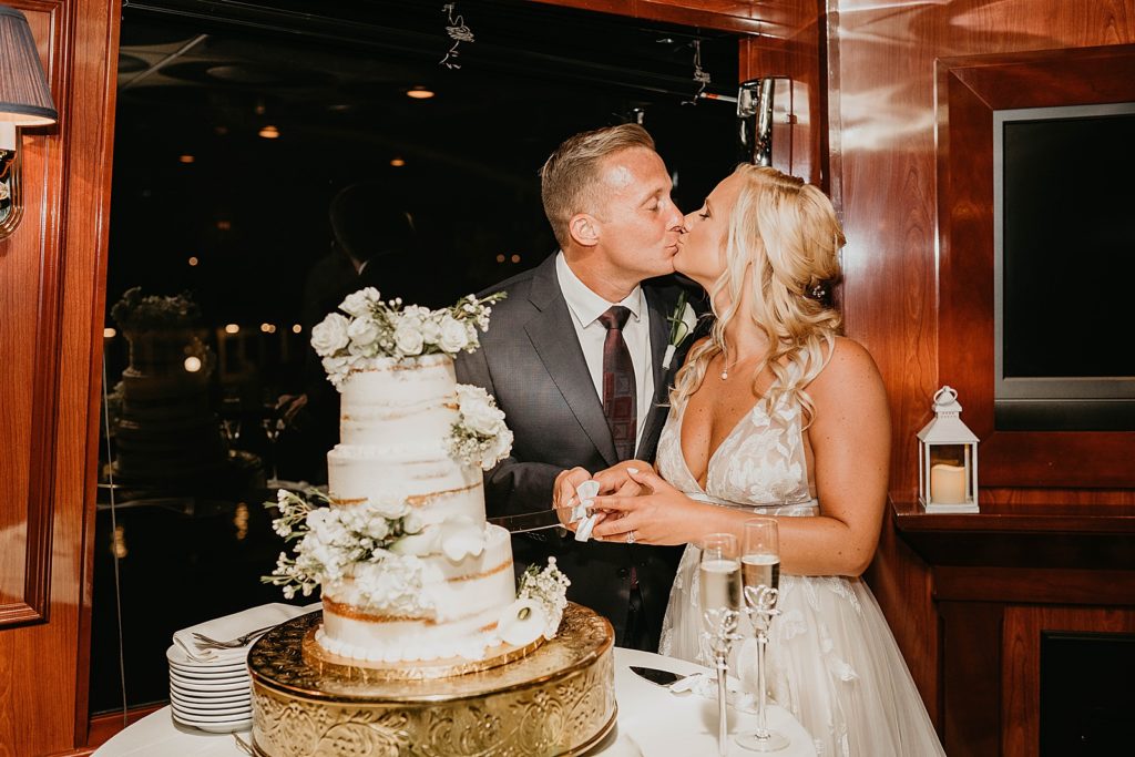Bride and Groom kissing during cake cutting