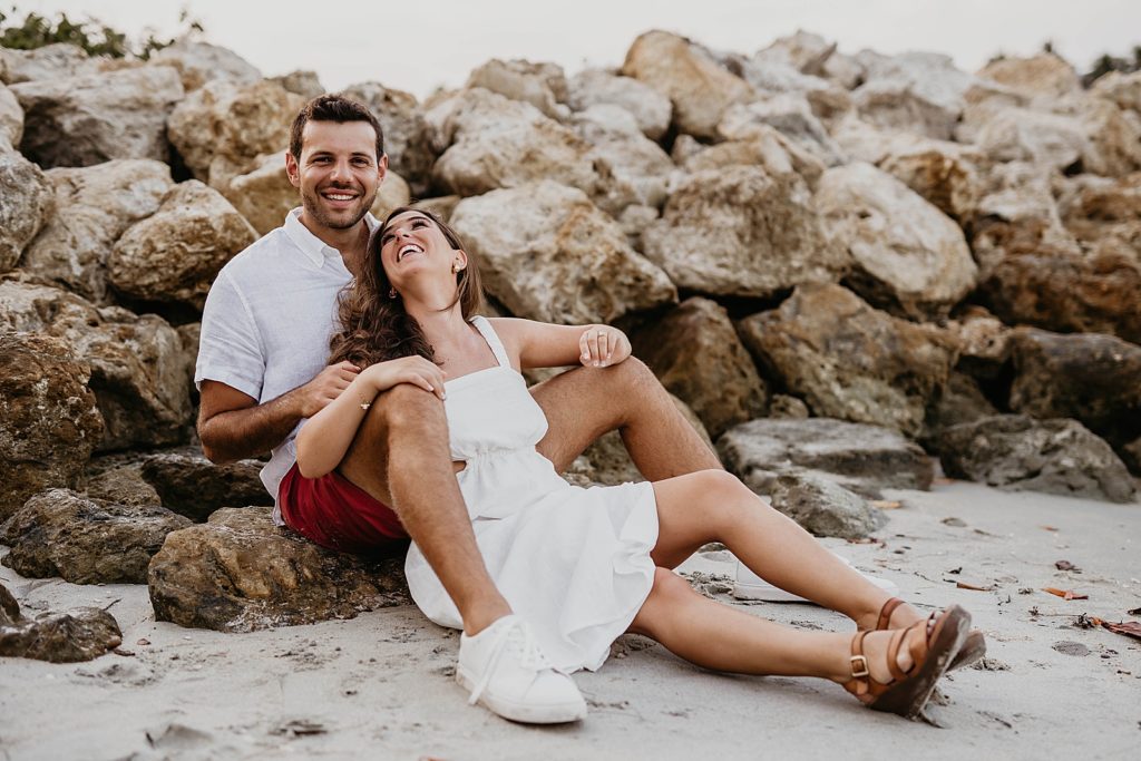 Couple sitting against the beach rocks