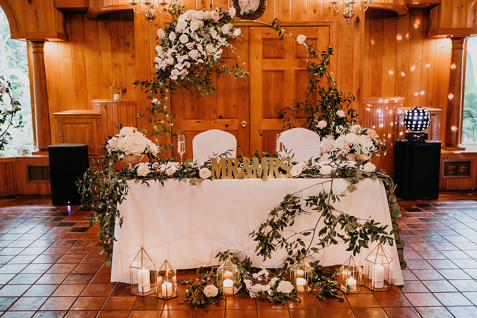 Detail shot of sweetheart table with candles and floral decor
