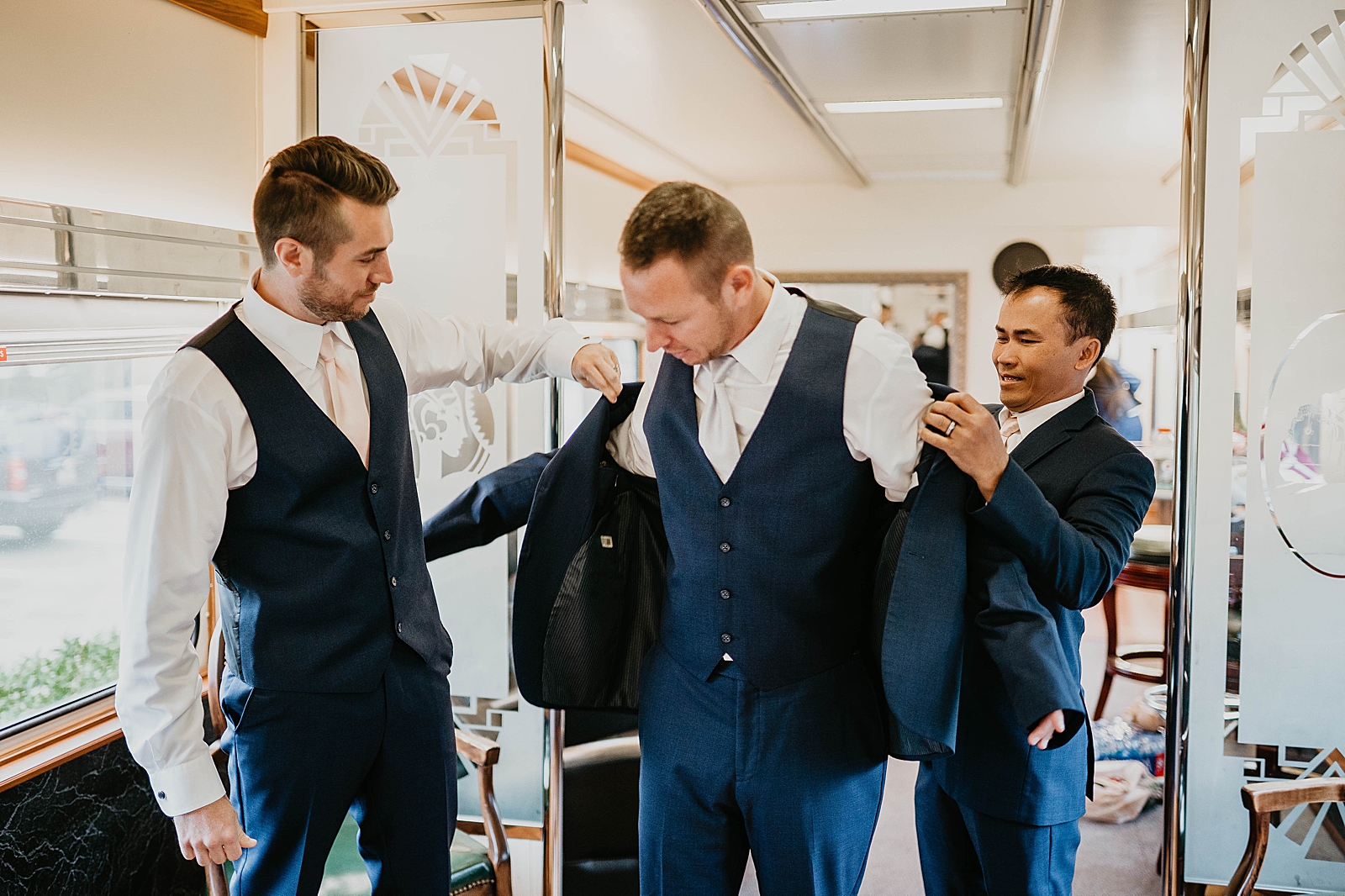 Groom getting ready putting on jacket