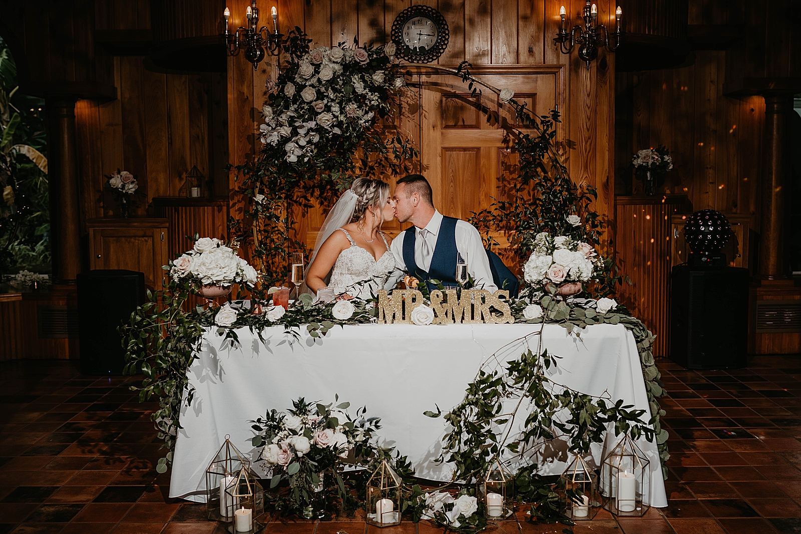 Bride and Groom kissing sitting at the sweetheart table