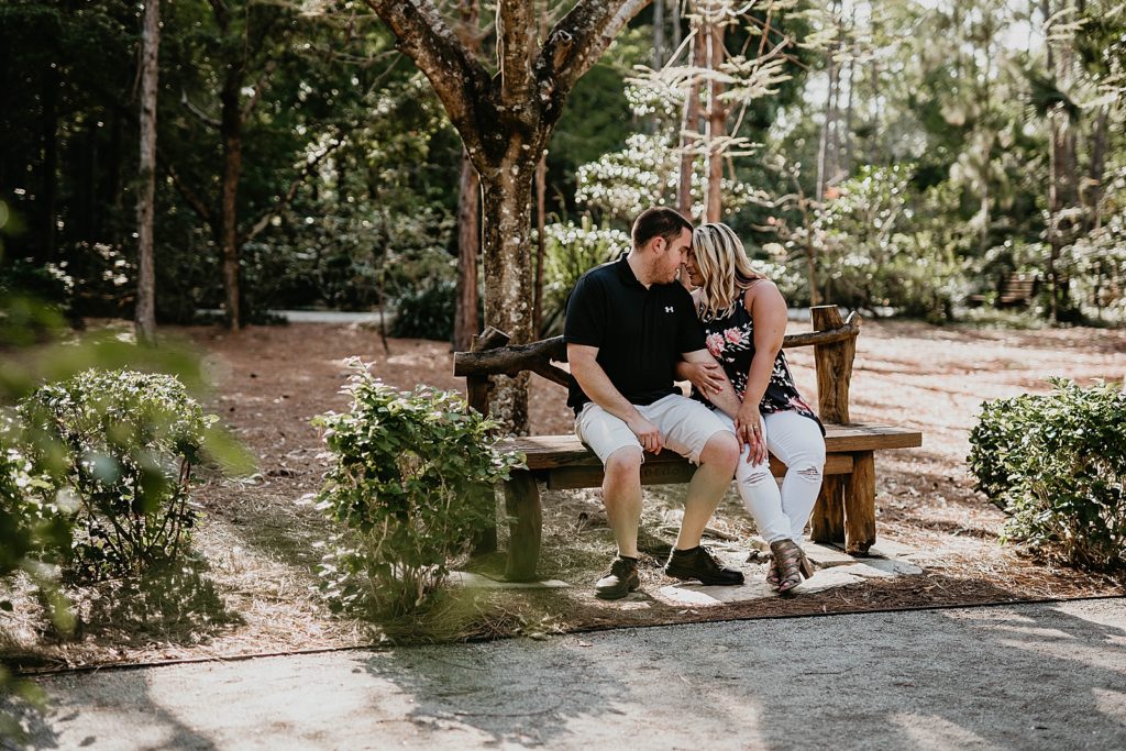 Couple sitting on the bench resting their heads against each other
