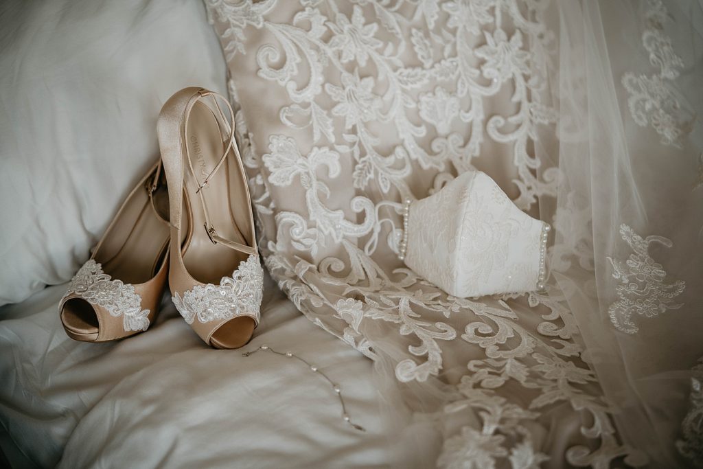 Detail shot of Bride custom wedding mask and wedding shoes