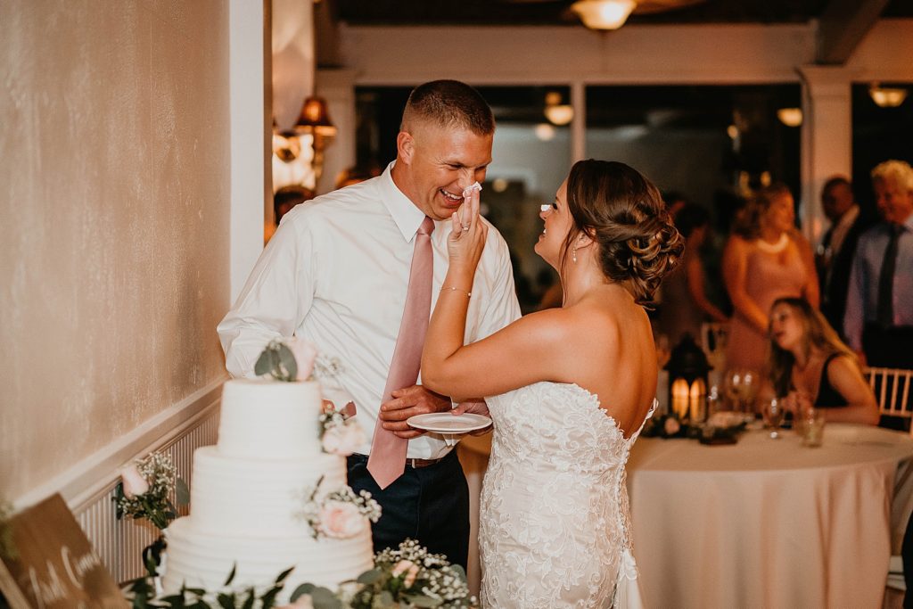 Bride smashing icing on Groom's nose after Cake cutting