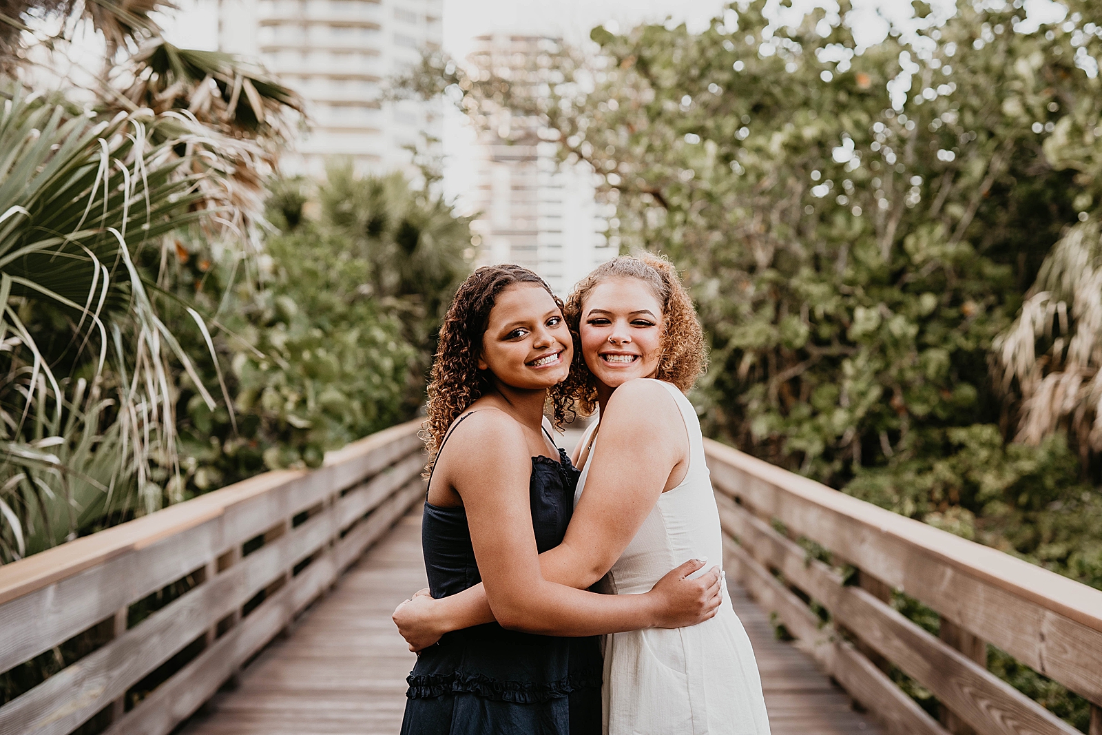 Sisters hugging on bridge