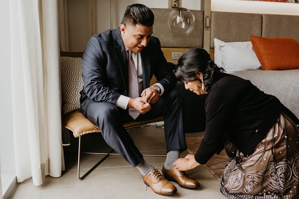 Groom getting help putting on shoes