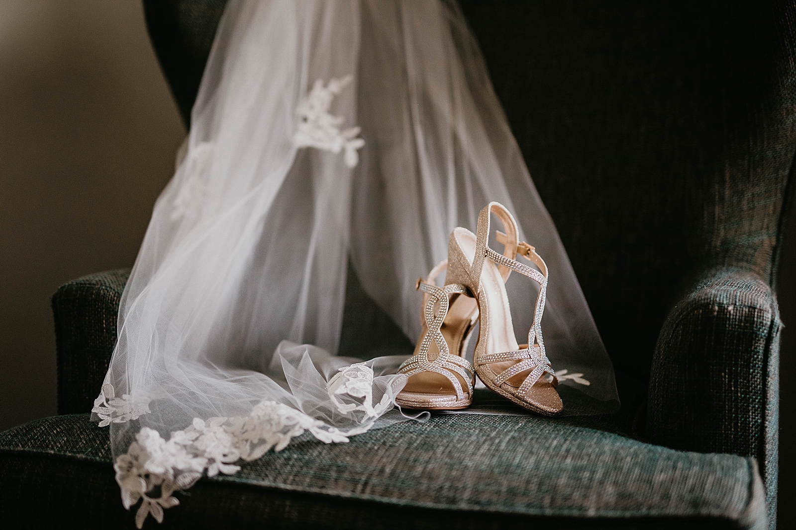 Detail shot of veil and wedding heels on chair